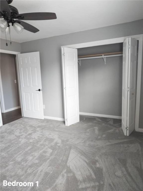 unfurnished bedroom featuring baseboards, dark carpet, and a closet