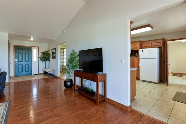 living room featuring high vaulted ceiling and light wood-type flooring