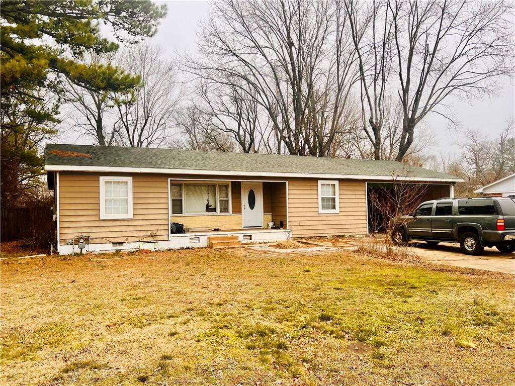 single story home featuring a garage and a front lawn