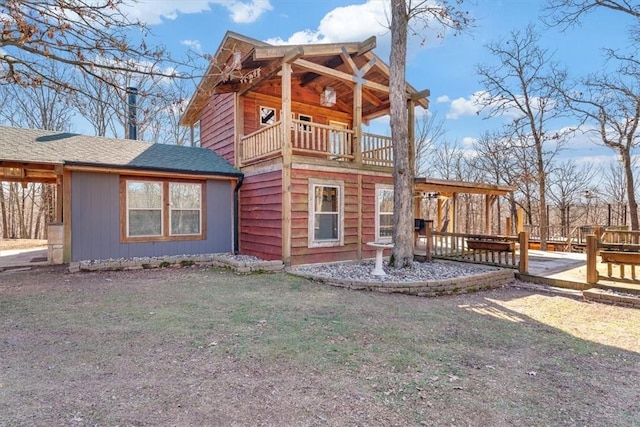 exterior space featuring a balcony and a yard