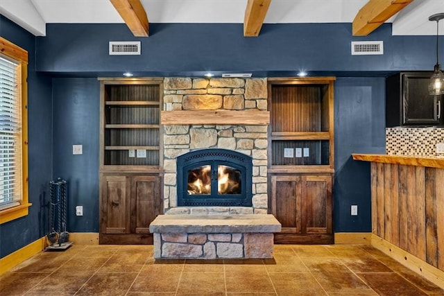 living room with tile patterned flooring, a stone fireplace, a wealth of natural light, and beamed ceiling