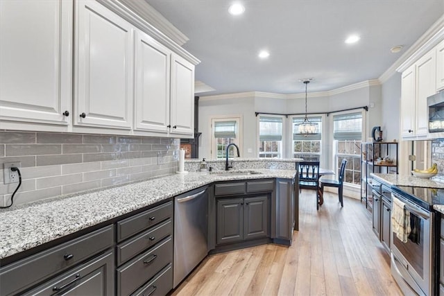 kitchen with sink, crown molding, appliances with stainless steel finishes, light stone countertops, and white cabinets