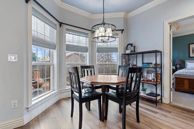 dining room with ornamental molding, light hardwood / wood-style floors, and a chandelier