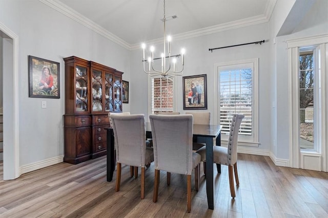 dining space featuring ornamental molding, a healthy amount of sunlight, and light wood-type flooring