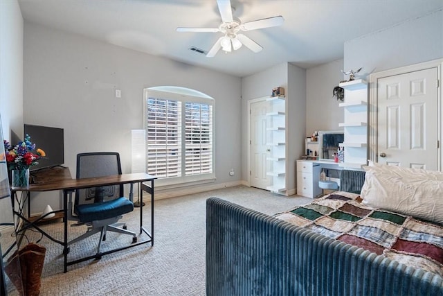 office space featuring light colored carpet, ceiling fan, visible vents, and baseboards