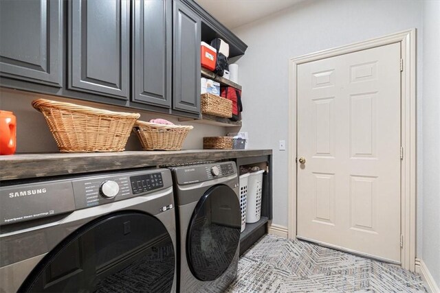 clothes washing area with cabinets and separate washer and dryer