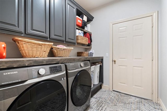 laundry area featuring baseboards, cabinet space, and washing machine and clothes dryer