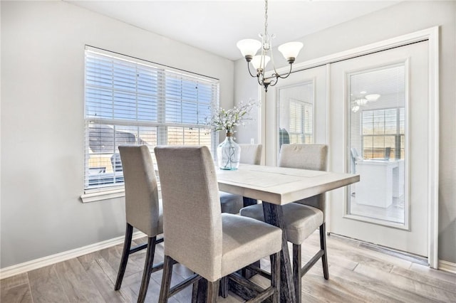 dining area featuring an inviting chandelier and light wood-type flooring