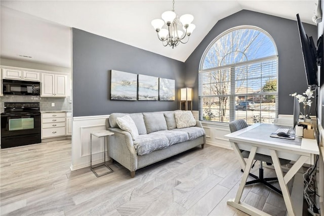 home office with high vaulted ceiling, light hardwood / wood-style floors, and a notable chandelier