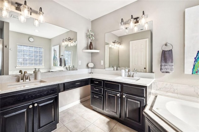 bathroom featuring tile patterned floors, vanity, and tiled tub