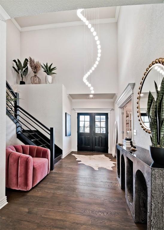 entryway with crown molding, dark hardwood / wood-style floors, french doors, and a textured ceiling