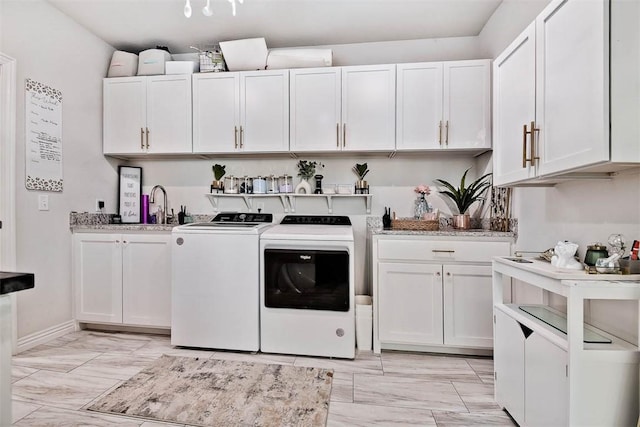 washroom with cabinets, sink, and washer and dryer