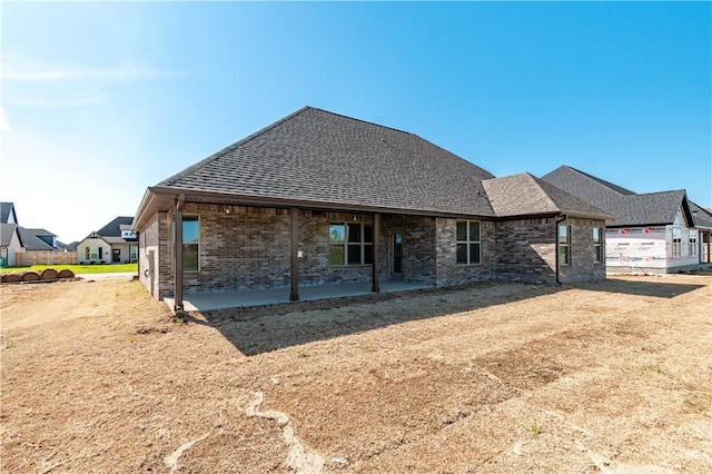 1200 Carrara St, Tontitown, AR 72762 - rear view of house with roof with shingles, brick siding, and a patio area