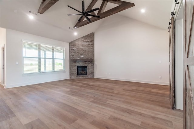 1200 Carrara St, Tontitown, AR 72762 - unfurnished living room with a barn door, beam ceiling, high vaulted ceiling, a ceiling fan, and light wood-style flooring