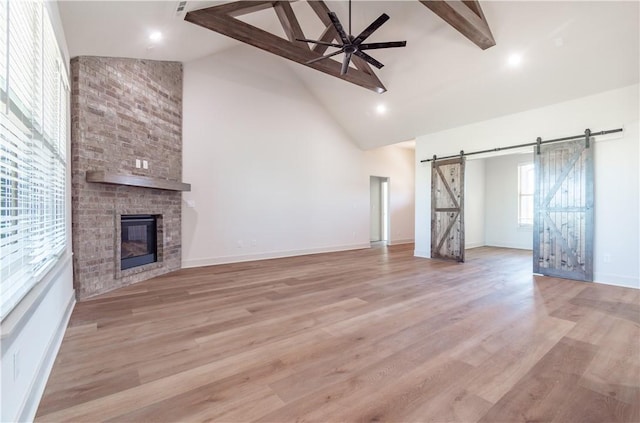 1200 Carrara St, Tontitown, AR 72762 - unfurnished living room with a barn door, high vaulted ceiling, beamed ceiling, ceiling fan, and a brick fireplace