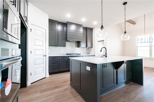 1200 Carrara St, Tontitown, AR 72762 - kitchen with a sink, stainless steel microwave, custom range hood, light wood finished floors, and recessed lighting