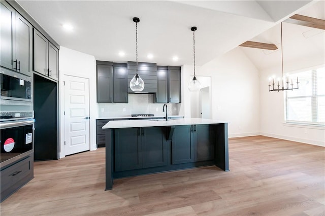 1200 Carrara St, Tontitown, AR 72762 - kitchen with appliances with stainless steel finishes, a sink, decorative backsplash, light countertops, and light wood-type flooring