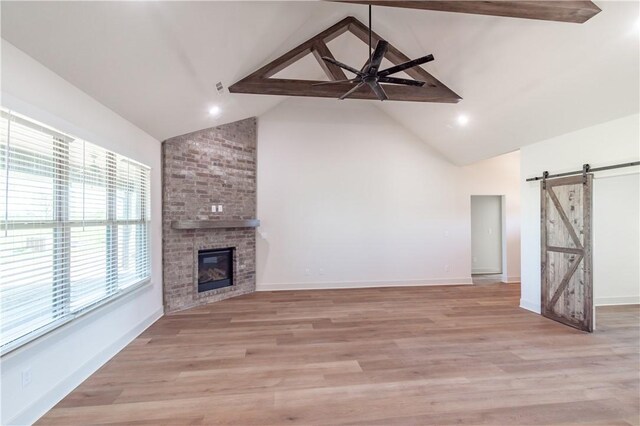 1200 Carrara St, Tontitown, AR 72762 - unfurnished living room with a barn door, a ceiling fan, high vaulted ceiling, beamed ceiling, and light wood-type flooring