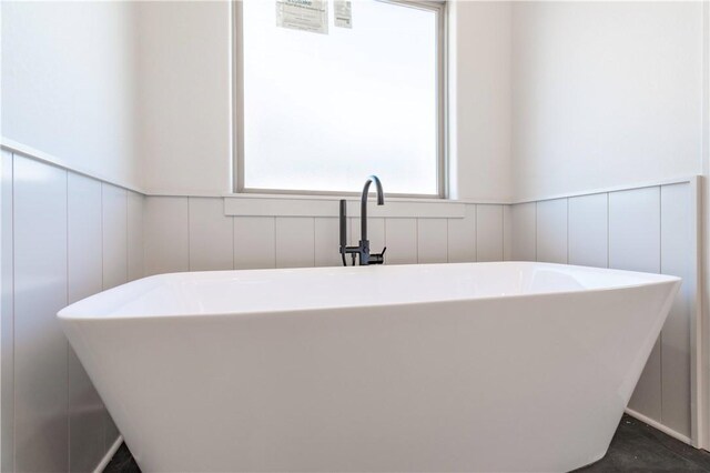 1200 Carrara St, Tontitown, AR 72762 - full bathroom featuring a decorative wall, wainscoting, and a soaking tub