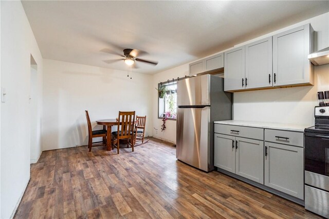 kitchen featuring dark wood finished floors, light countertops, gray cabinetry, ceiling fan, and stainless steel appliances