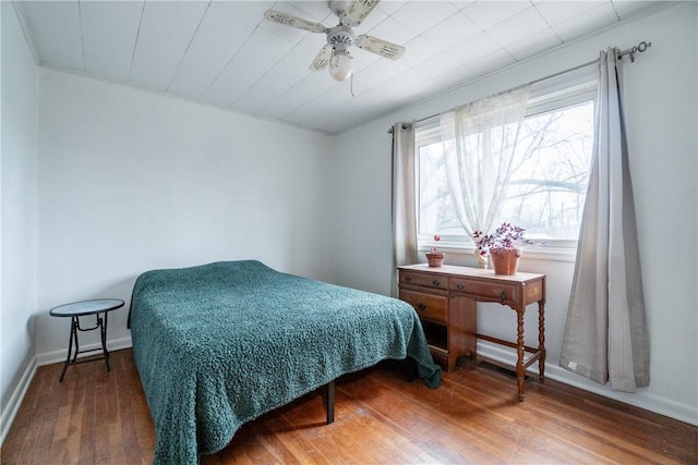 bedroom with wood finished floors, ceiling fan, and baseboards