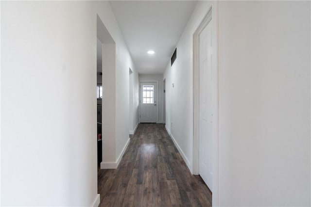 hallway with recessed lighting, visible vents, baseboards, and dark wood-style floors