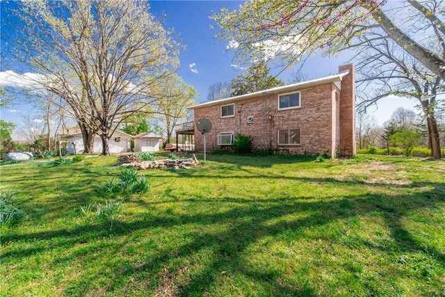 rear view of property featuring a yard, brick siding, a wall unit AC, and a chimney