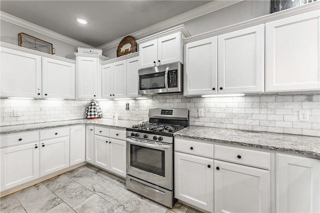 kitchen with decorative backsplash, appliances with stainless steel finishes, ornamental molding, and white cabinetry