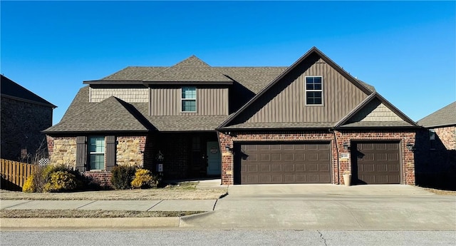 craftsman inspired home with a garage, roof with shingles, driveway, and brick siding