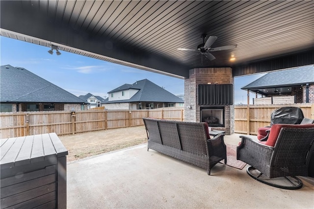 view of patio / terrace with an outdoor living space with a fireplace and ceiling fan