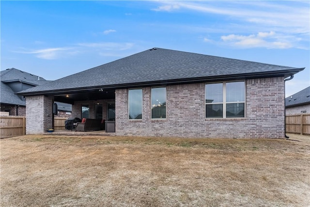 back of property featuring a patio area and a lawn