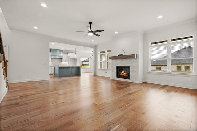 1808 Charles St, Pea Ridge, AR 72751 - unfurnished living room with a ceiling fan, light wood-style flooring, crown molding, a glass covered fireplace, and recessed lighting