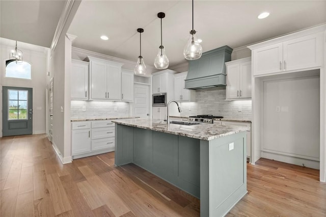 1808 Charles St, Pea Ridge, AR 72751 - kitchen featuring stainless steel microwave, ornamental molding, decorative backsplash, white cabinetry, and premium range hood