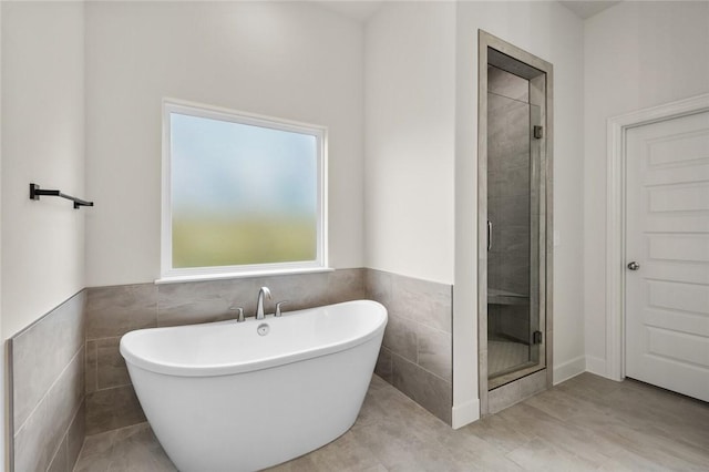 1808 Charles St, Pea Ridge, AR 72751 - bathroom with a soaking tub, a stall shower, tile walls, a wainscoted wall, and tile patterned flooring