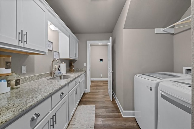 laundry area with dark wood-type flooring, cabinets, separate washer and dryer, and sink