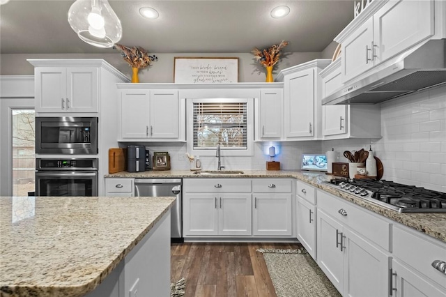 kitchen with white cabinetry, stainless steel appliances, sink, and hanging light fixtures