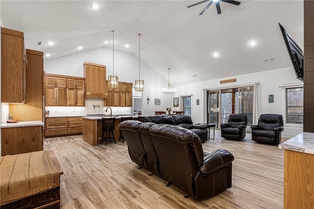 living room with visible vents, high vaulted ceiling, light wood-style flooring, and recessed lighting