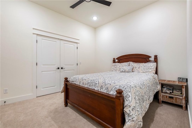 bedroom with light carpet, a closet, and ceiling fan