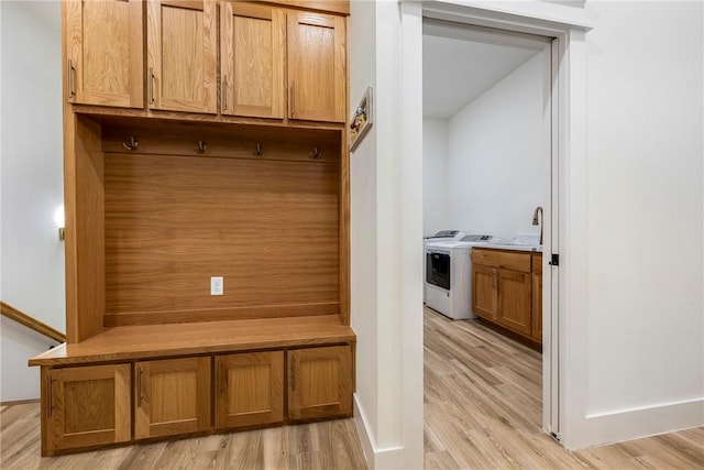 mudroom featuring washer / clothes dryer, sink, and light hardwood / wood-style flooring