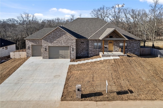 view of front of property featuring an attached garage, fence, concrete driveway, and brick siding