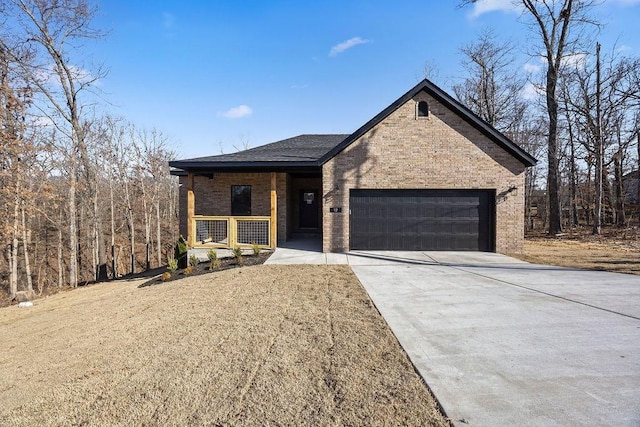 view of front facade featuring roof with shingles, a porch, an attached garage, concrete driveway, and brick siding