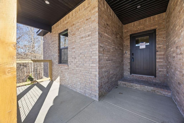 view of exterior entry featuring brick siding