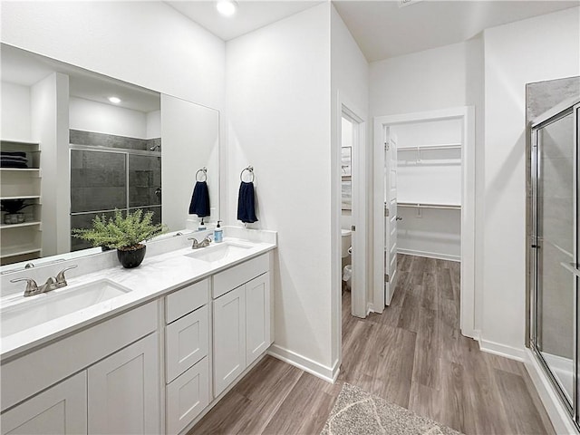 bathroom featuring vanity, hardwood / wood-style floors, toilet, and walk in shower