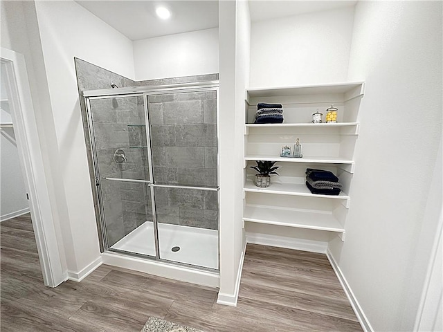 bathroom featuring hardwood / wood-style flooring and walk in shower