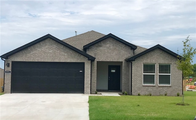 view of front of home with a garage and a front lawn