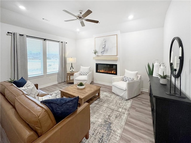 living room with ceiling fan and light hardwood / wood-style floors