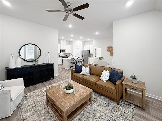 living room featuring light hardwood / wood-style floors and ceiling fan