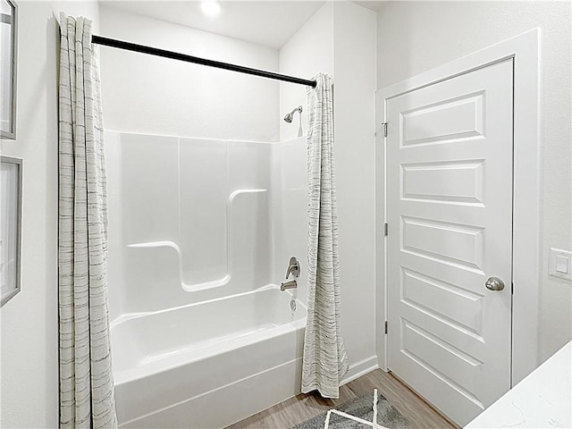 bathroom featuring shower / bathtub combination with curtain and hardwood / wood-style floors