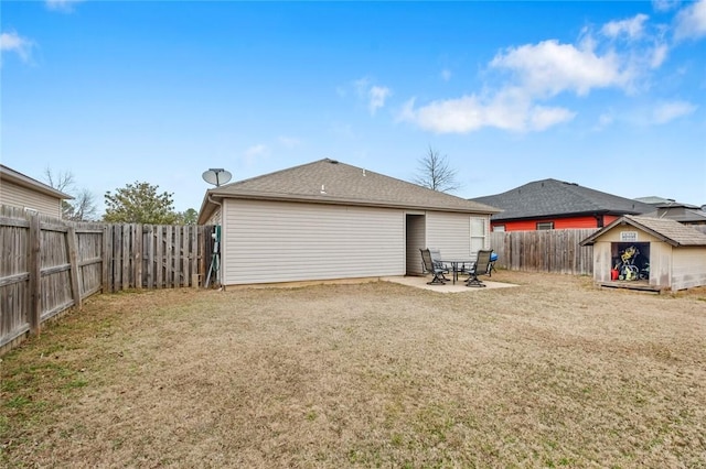 rear view of property featuring a lawn, a shed, and a patio area