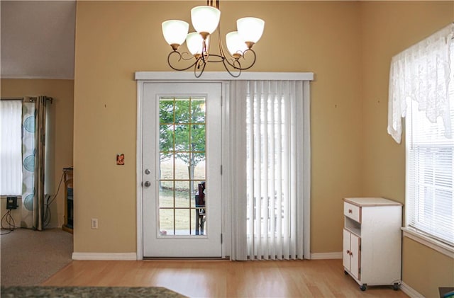 entryway with an inviting chandelier and light hardwood / wood-style floors